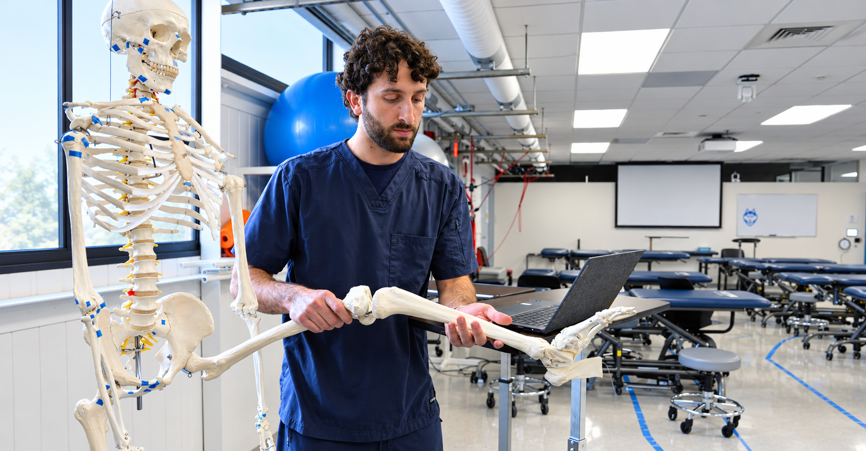Hall instructor hold skeletal leg in lab.